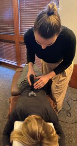 Client getting spinal adjustment using Impulse instrument
